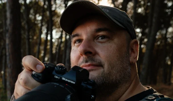 Photographer Petr Bambousek holding the OM-1 Mark II for nature photography